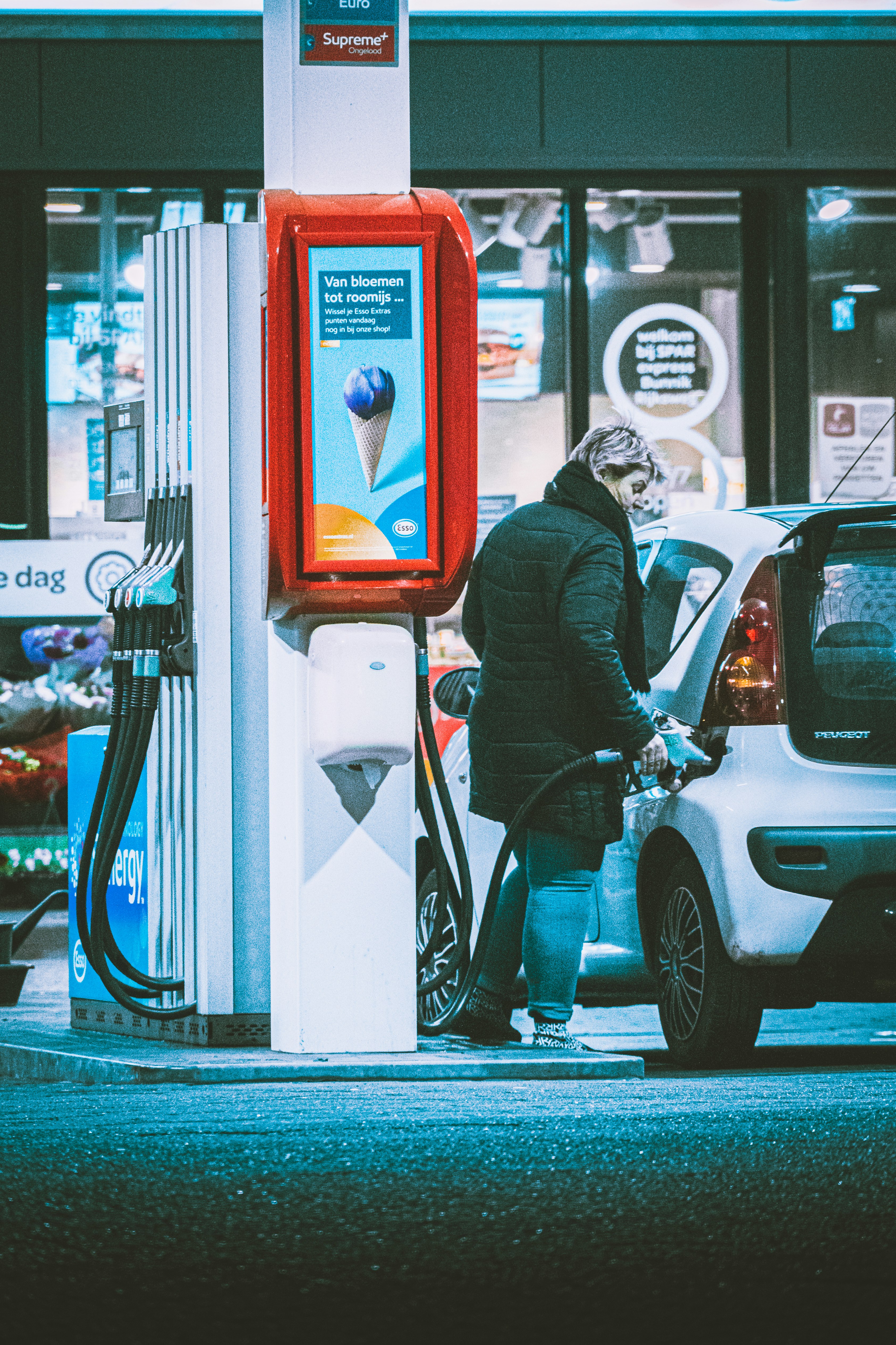 man in black suit standing beside white car